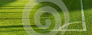 Green grass football or soccer field with white corner line banner background