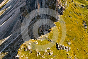 Green grass grows on steep slope of rocky Seceda mountain