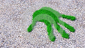 Green grass handprint on gravel background