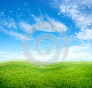 Green grass hills under blue sky.