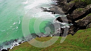 The green grass and rocky coastline of Dingle Peninsula in Ireland