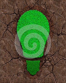 Green grass in the shape of light bulb on dry red soil with cracks background, concept of ECO and renewable energy