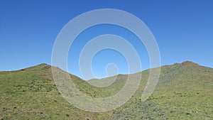 Green grassy mountains against a breautiful bright blu sky