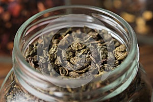Green gunpowder tea. Green tea leaves in an open glass jar for storing tea