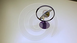 Green gyroscope or toy at white table. Footage. Gyroscopic exercise tool for the prevention of carpal tunnel syndrome