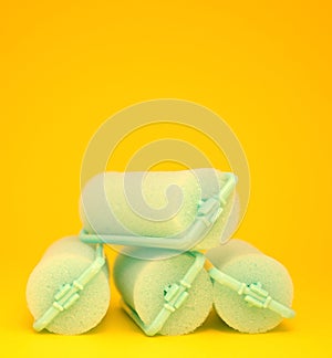 Green Hair Curlers on a yellow background