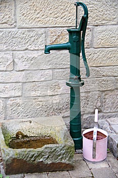 Green hand pump with pink watering can