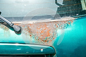 Green hatchback car back or fifth door damaged rusty and corroded paint spots