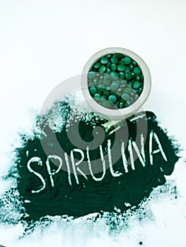 Green hawaiian spirulina in powder with inscription Spirulina on light white background