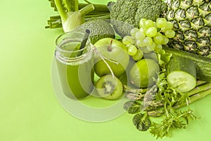 Green health smoothie fruits and vegetables, kale leaves, lime, apple, kiwi, grapes, banana, avocado, lettuce pineapple