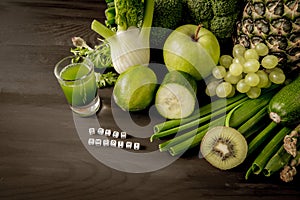 Green health smoothie fruits and vegetables, kale leaves, lime, apple, kiwi, grapes, banana, avocado, lettuce pineapple