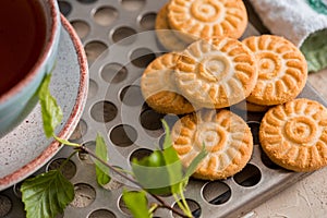 Green herbal tea is served on a metal vintage antique retro tray with homemade cakes - round biscuit biscuits. on a