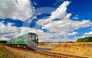 Green Heritage Railcar in Summer Countryside