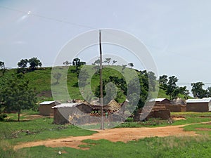 A green hill with a clear sky in a sunny day surrounded by houses