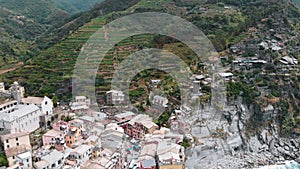 Green hill and Vernazza town, famous Cinque Terre. Summer daylight drone shot