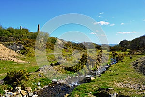 Green hill and a water stream in Bodmin Moor area near old mining shaft