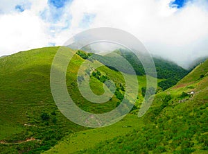Green hills. Mountains and clouds