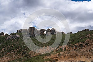 Green hills under blue sky and white clouds