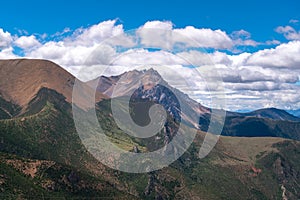 Green hills under blue sky and white clouds