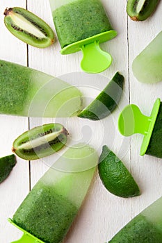 Green homemade ice cream on white wooden background. Fruit ice with kiwi and lime. Top view.