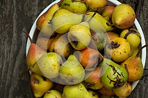 Green homemade pear in a plate stands on a wooden table