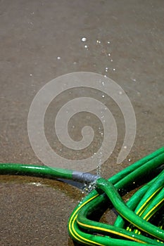 Green Hose Leaking Spraying Water