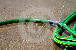 Green Hose Leaking Spraying Water