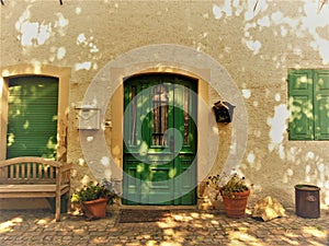 Green house door and green shutters with clay planters