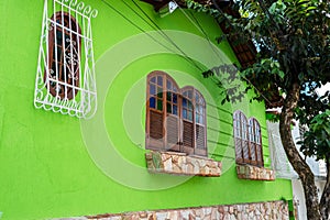 Green House Facade with Wooden Window with Colored Glass.