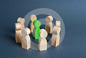 A green human figure is surrounded by a circle of people. Cooperation and collaboration. Fundraising and people around the idea.