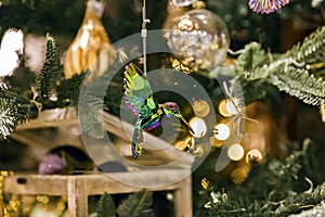 Green hummingbird ornament hanging in christmas tree