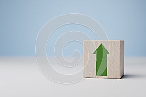 Green increasing up arrow on wooden cube block. business investment growth concept. Business growth, profit, benefit, income,