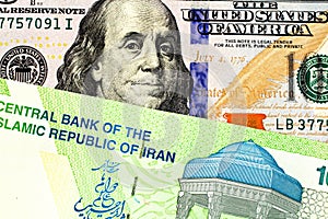 A green Iranian ten thousand rial bill with an American one hundred dollar bill