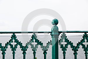 Green Iron fence details with the sea in the background