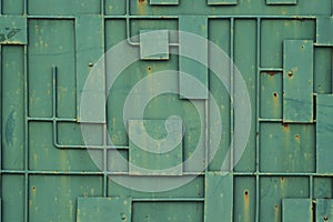 Green iron fence with a pattern of geometric lines of metal.