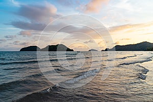 Green islands and reflected sea wave with blue, yellow sky color in background in the evening in Koh Mak Island at Trat, Thailand