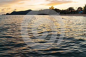 Green islands and reflected sea wave with blue, yellow sky color in background in the evening in Koh Mak Island at Trat, Thailand