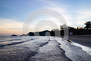 Green islands and reflected sea wave with blue, yellow sky color in background in the evening in Koh Mak Island at Trat, Thailand