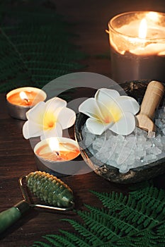 Green jade massage roller against the background of turn signals and burning candles on the table