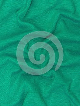 Green jersey fabric matte texture top view. Lime knitwear background. Fashion color trendy clothes. Website backdrop