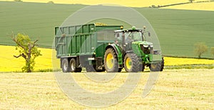 A green John Deere tractor and Bailey trailer