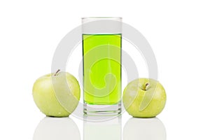 Green juice standing between two green apples with water drops on surface on white background.