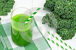 Green kale smoothie with straws on checkered cloth