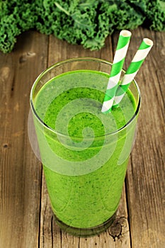 Green kale smoothie on wood background