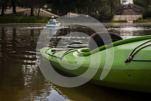 Green kayak on the river bank