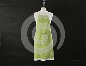 Green Kitchen Apron On Mannequin Over Black Background