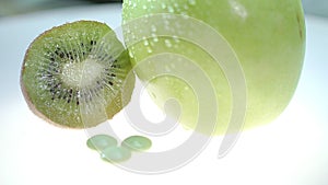 Green kiwi and apple fruit with vitamin tablet. Summer vitamin pills