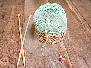 Green knitting yarn on wooden background