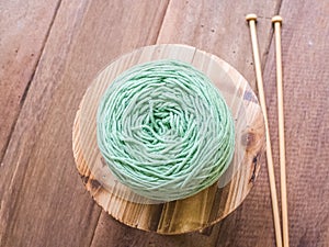 Green Knitting yarn on wooden background