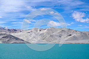 Green lake, snow mountain, white clouds, blue sky